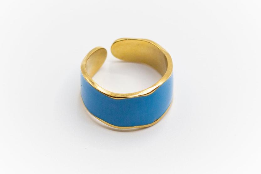 Anillo ajustable de acero inoxidable dorado con acrílico azul.