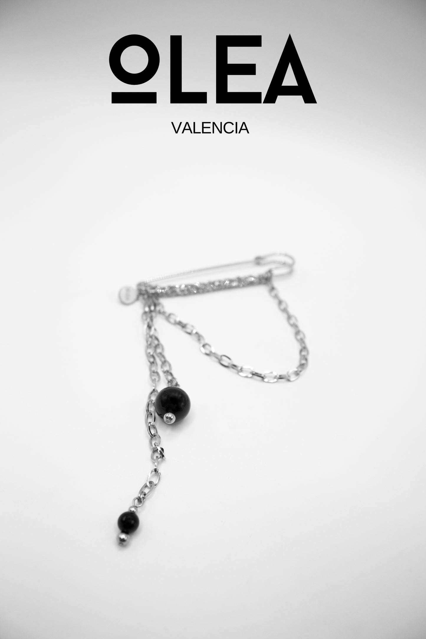 Silberfarbene Edelstahlbrosche mit Kristallen und natürlichem Onyxstein