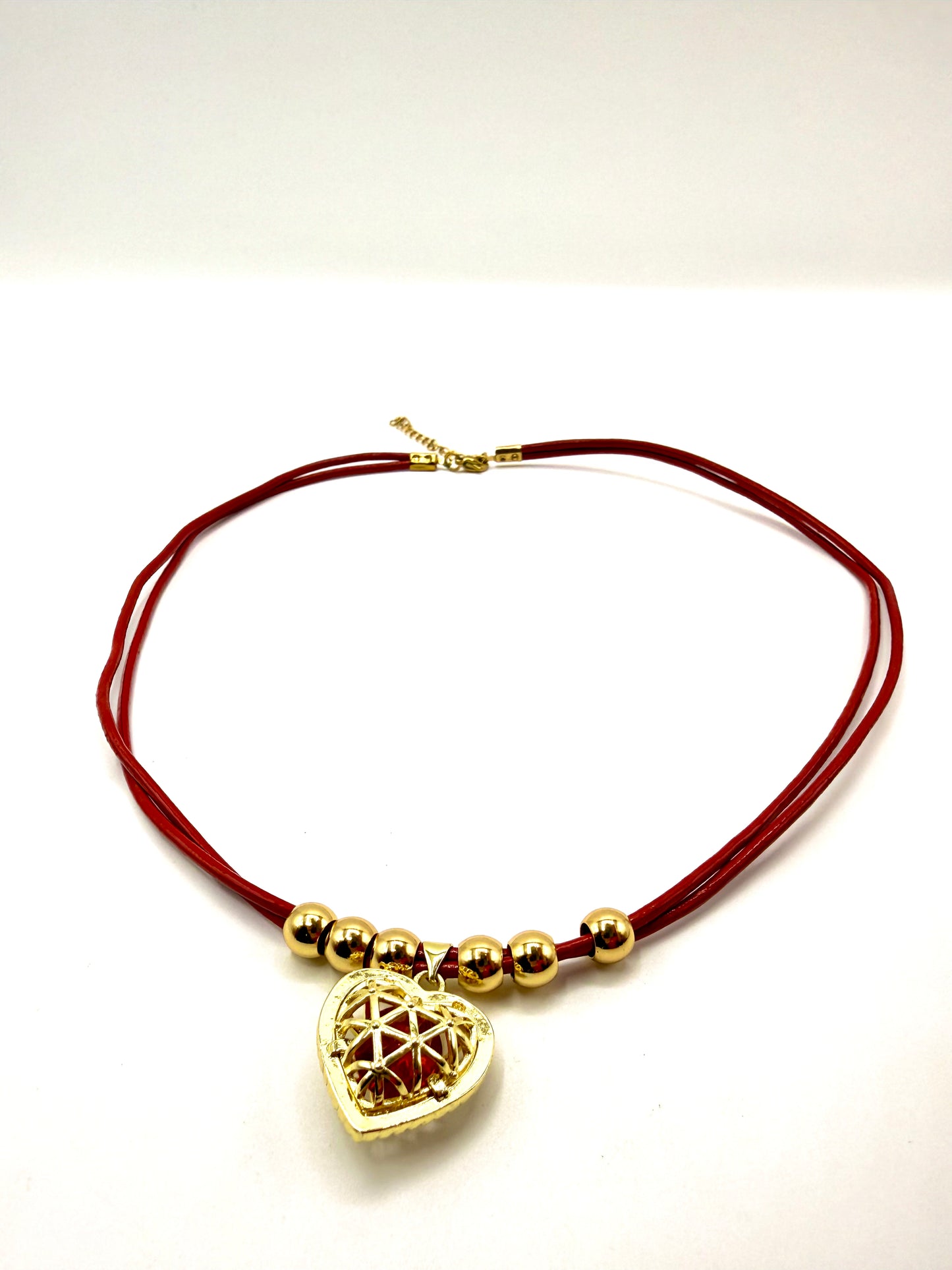 collar cuero rojo con colgante de corazón calado y detalles de acero inoxidable bañado en oro de 14K