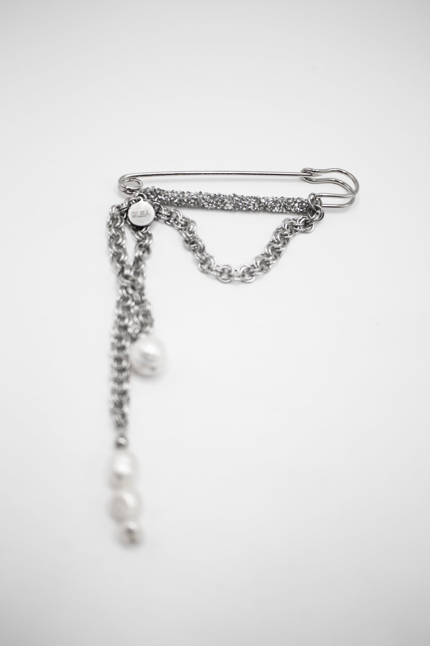 Silberfarbene Edelstahlbrosche mit Kristallen und Naturperle