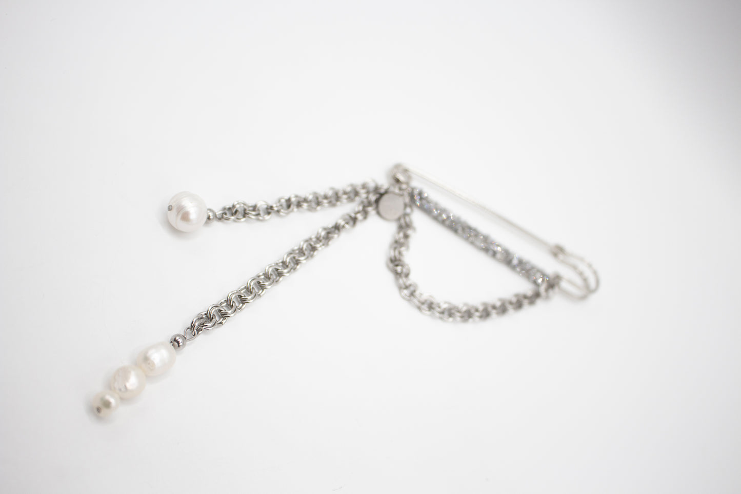 Silberfarbene Edelstahlbrosche mit Kristallen und Naturperle