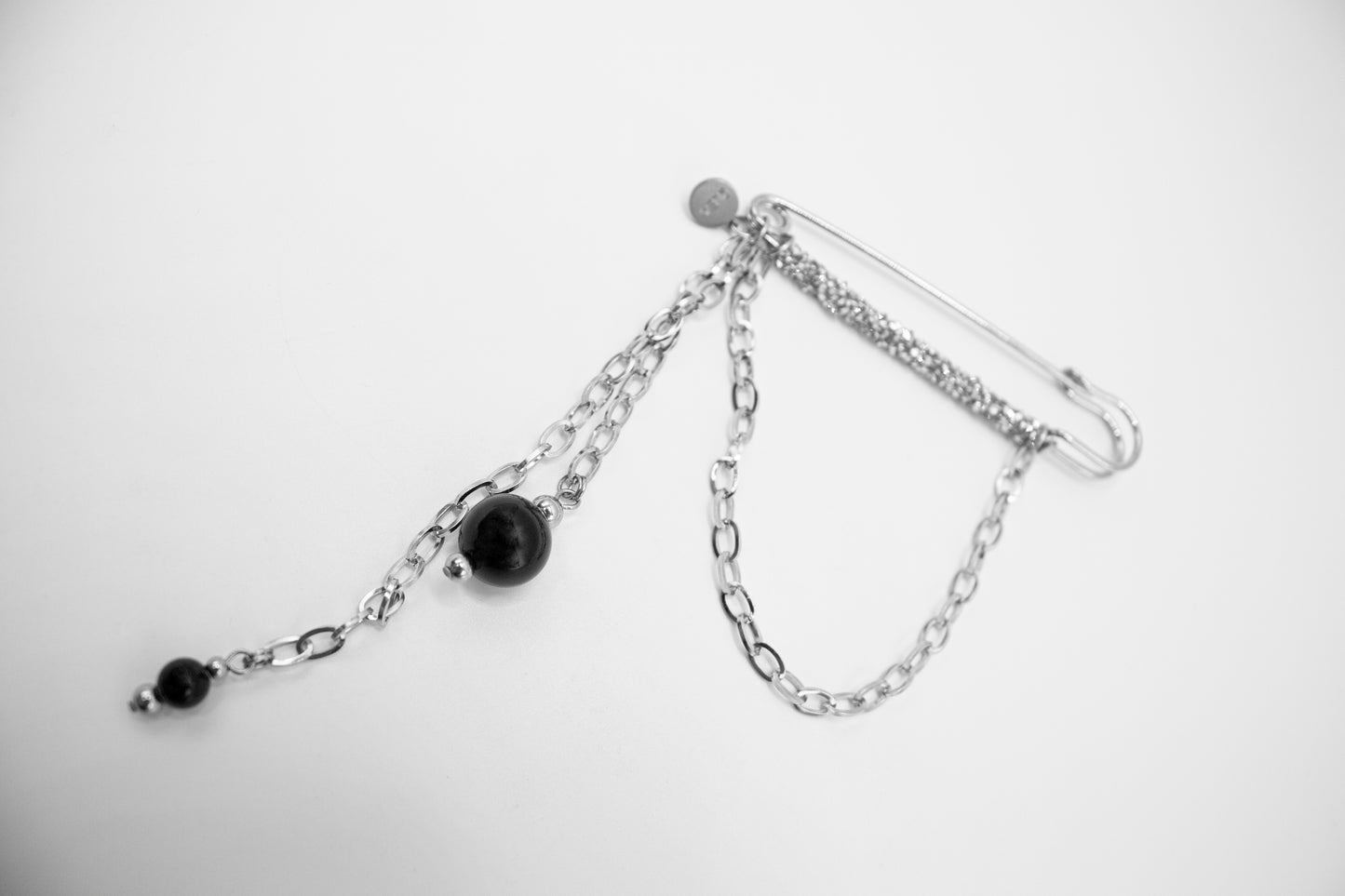 Silberfarbene Edelstahlbrosche mit Kristallen und natürlichem Onyxstein