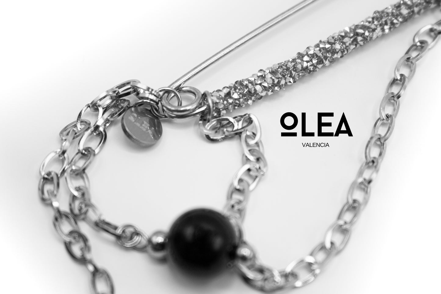 Silberfarbene Edelstahlbrosche mit Kristallen und natürlichem Onyxstein