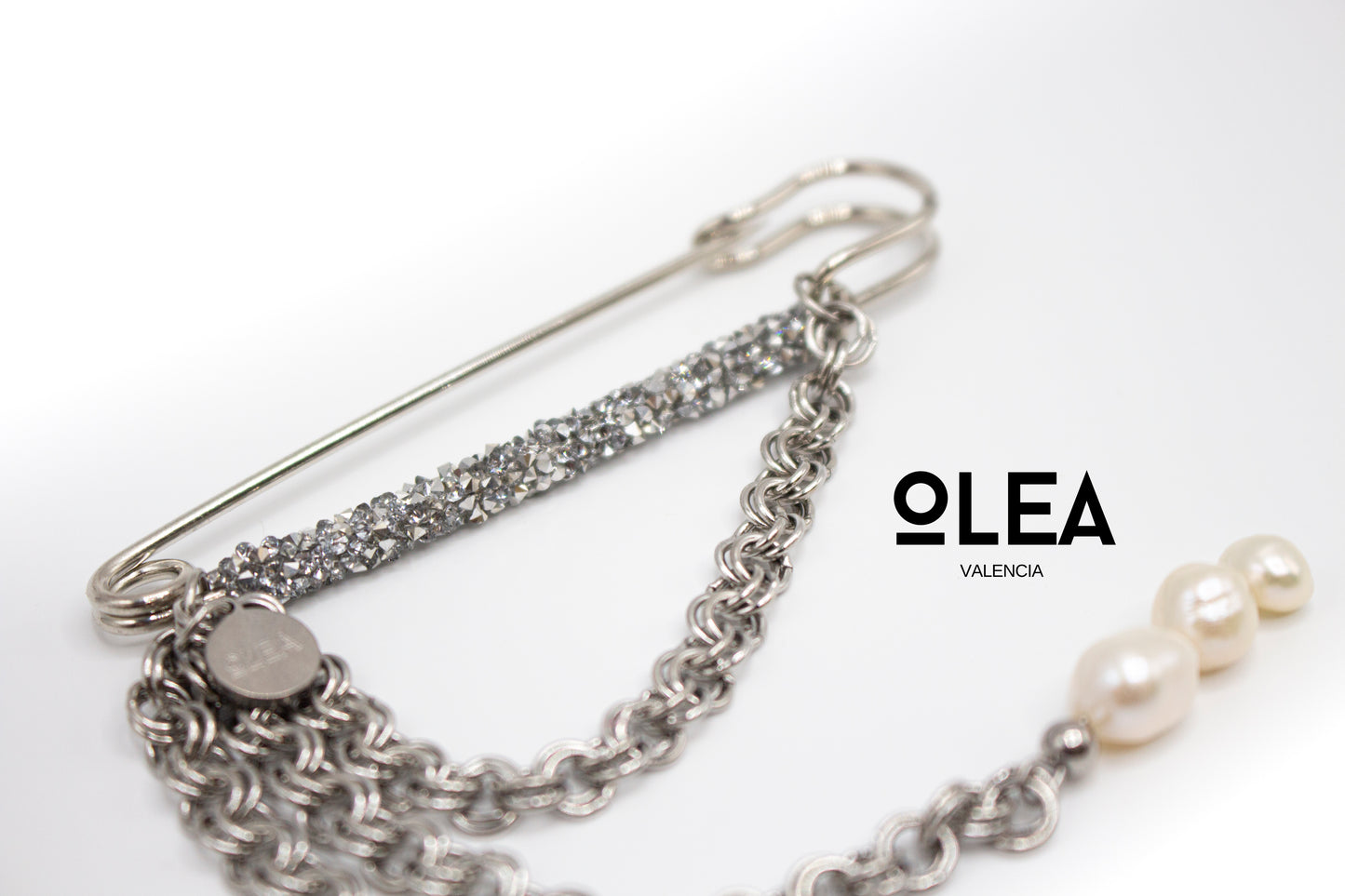 Silberfarbene Edelstahlbrosche mit Kristallen und Naturperle