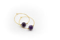 Goldfarbene Creolen aus Edelstahl mit einem natürlichen Amethyststein