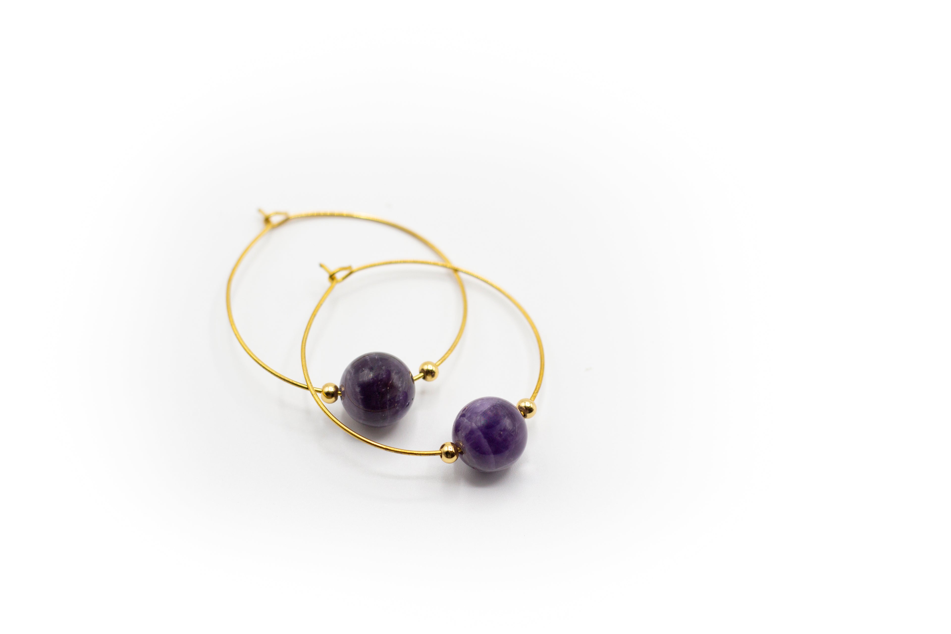 Goldfarbene Creolen aus Edelstahl mit einem natürlichen Amethyststein