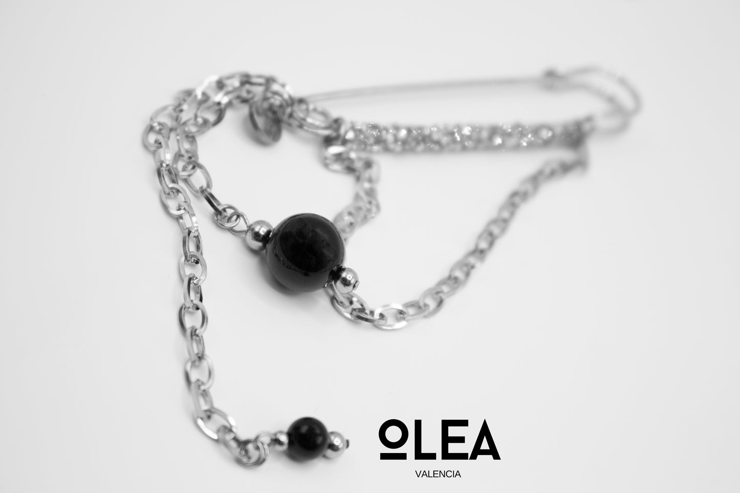 Silberfarbene Edelstahlbrosche mit Kristallen und natürlichem Onyxstein